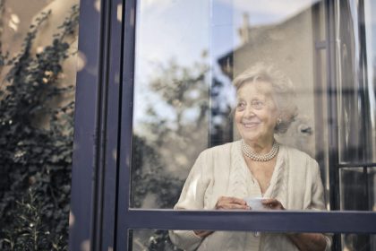 signora anziana dietro una finestra