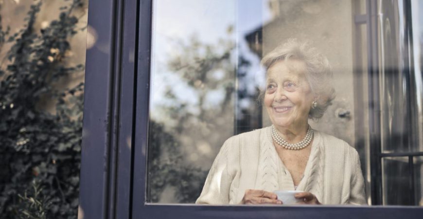 signora anziana dietro una finestra